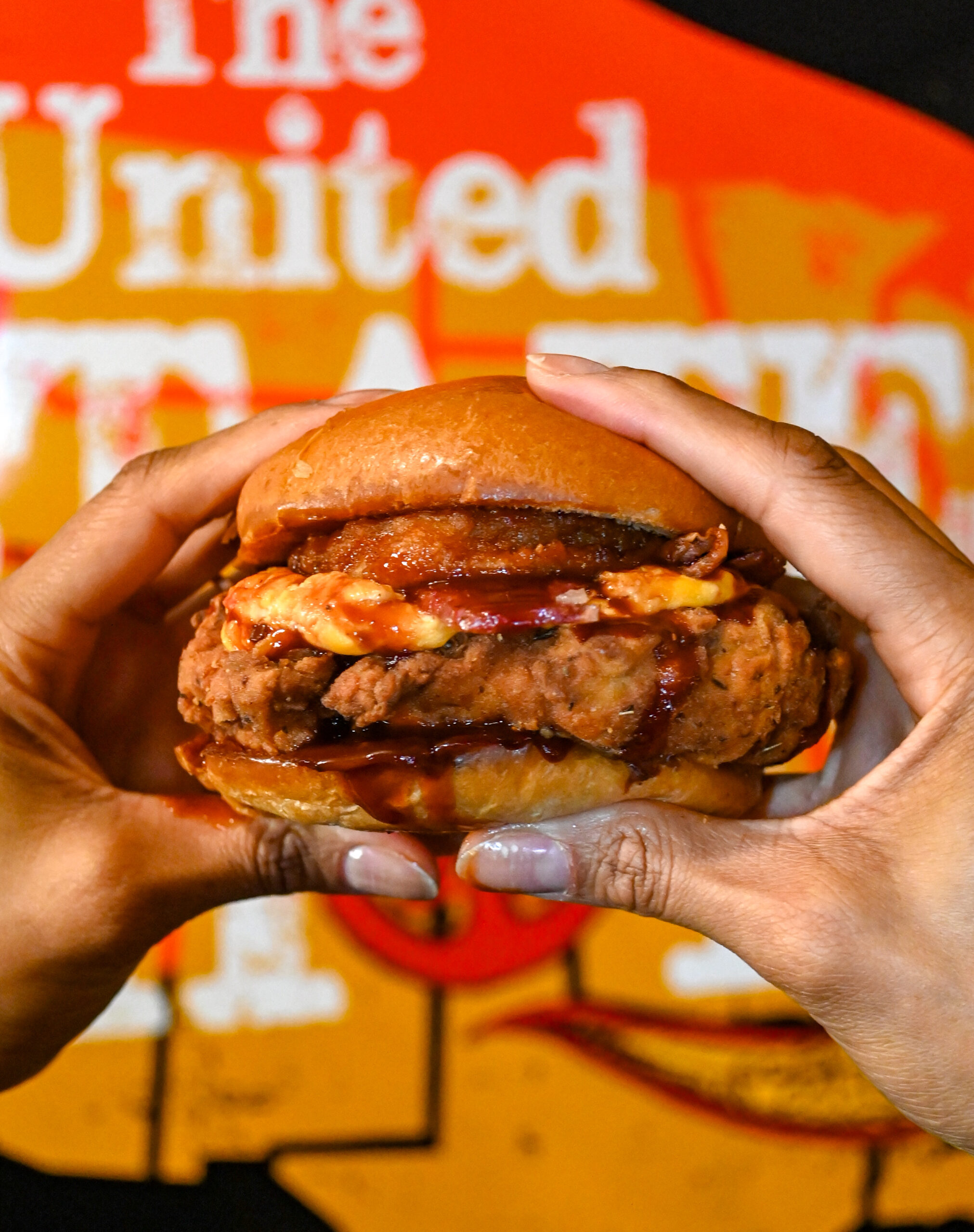 Image of a burger being held by two hands with